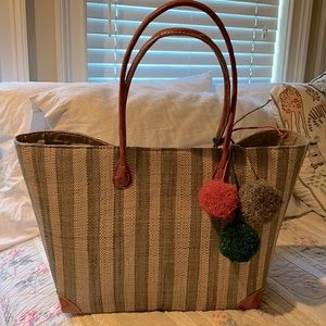 Wicker striped bag with three pom-poms